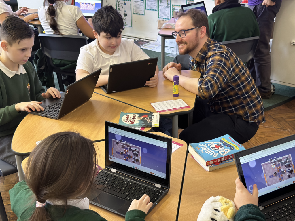 Teacher working with students in round table discussion on personal laptops
